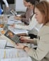 Kosmetikerinnen arbeiten während einer ANS Schulung mit fachlichen Unterlagen und Arbeitsmaterialien