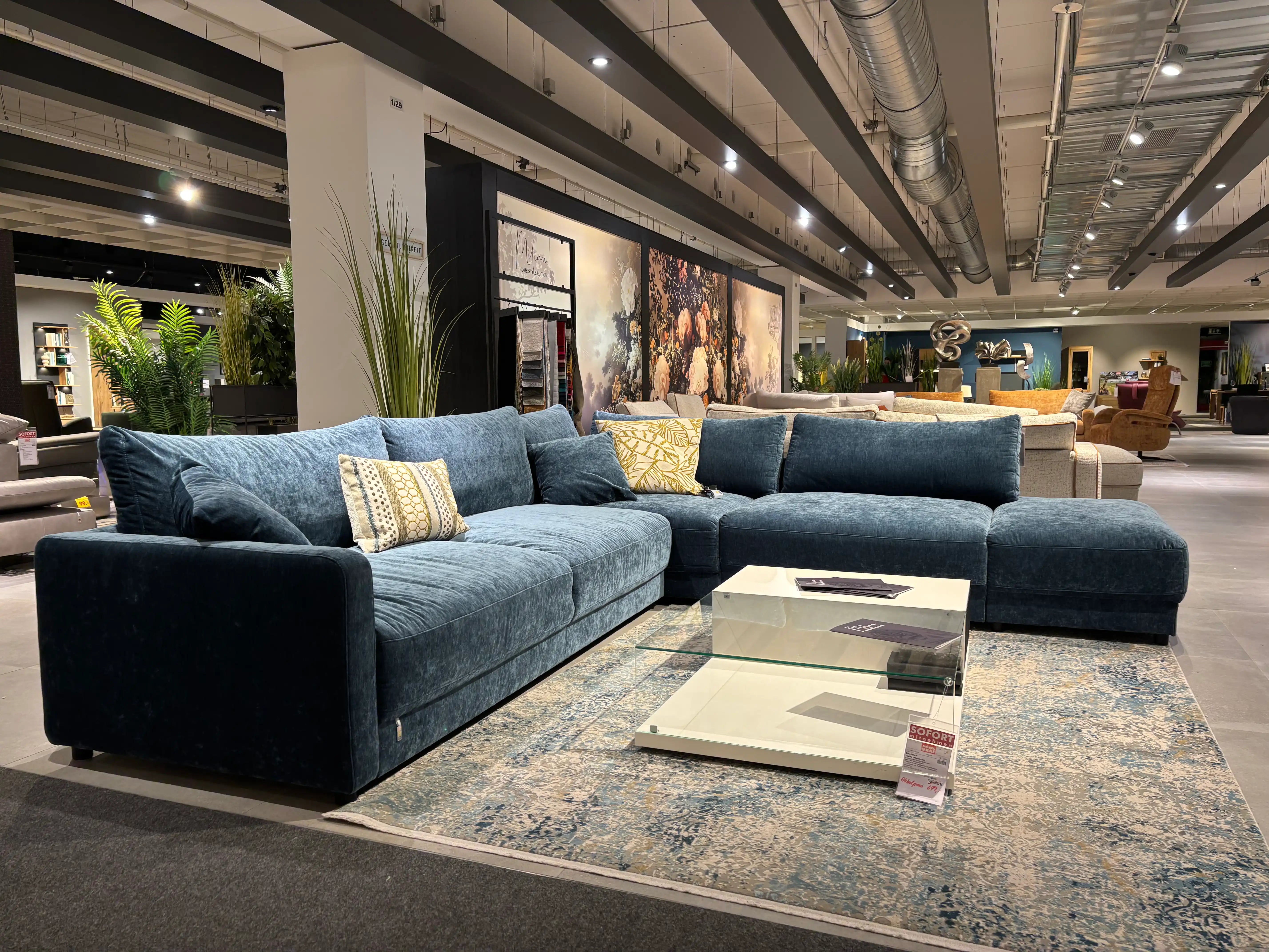 Großes blaues Ecksofa aus Samt mit Couchtisch in der Ausstellung