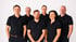 Das Team von Meiser Küchenstudio in schwarzen Poloshirts stehen in zwei Reihen vor einem weißen Hintergrund und blicken in die Kamera.