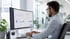 Mann mit Brille arbeitet an einem Computermonitor, der ein Dashboard mit Grafiken und Diagrammen anzeigt.