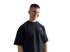 Ein lächelnder junger Mann mit kurzen Haaren und schwarzem T-Shirt steht vor grünem Hintergrund.