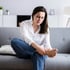 Woman on couch holding foot, focused on nerve regeneration