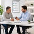 At a desk, a doctor shows a man a meter and discusses nerve pain relief.