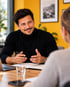 Marc-Michael Schoberer im Gespräch mit einer Mitarbeiterin an einem Besprechungstisch