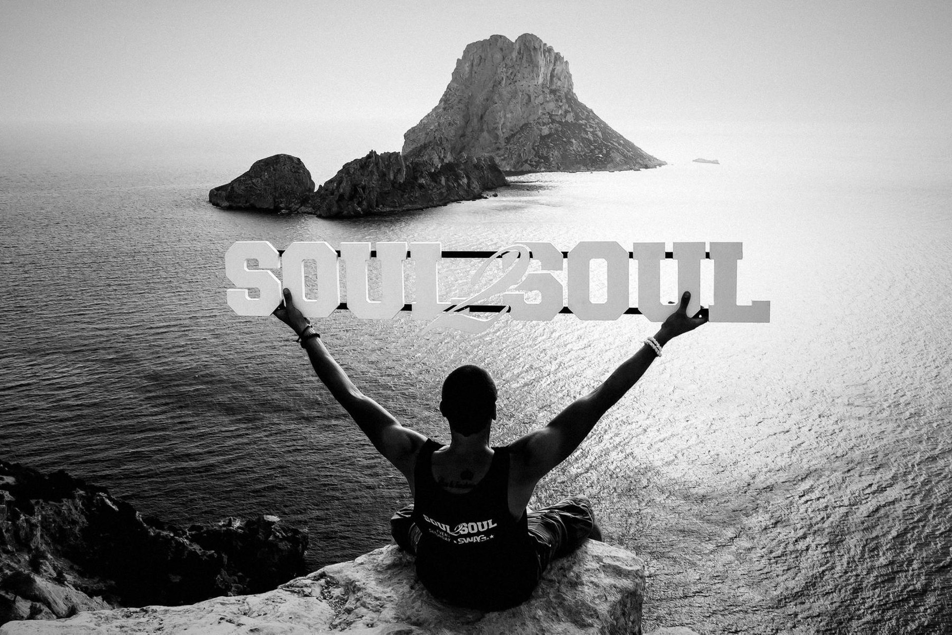 Es Vedrà bei Sonnenuntergang, im Vordergrund der Soul2Soul-Schriftzug über dem Meer