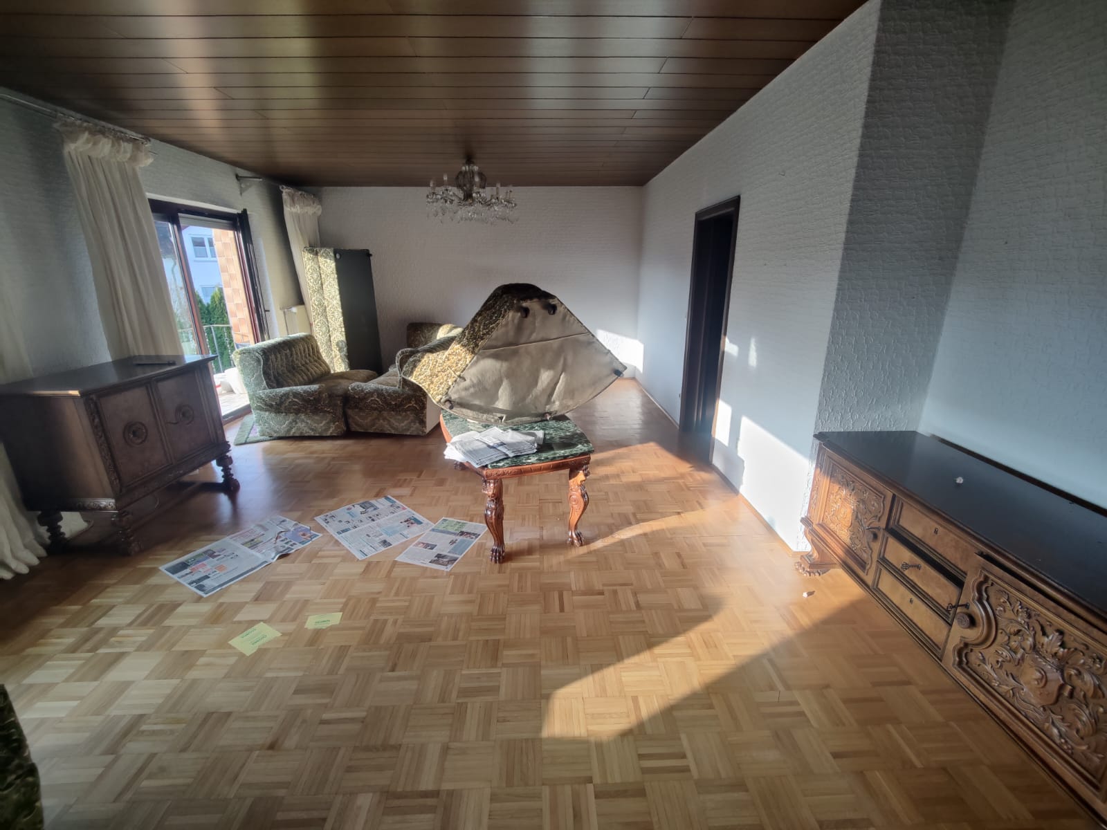 Wohnzimmer vor der Entrümpelung mit Möbeln und Unrat