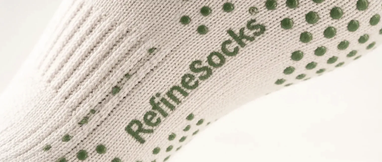 Extreme Nahaufnahme einer weissen Grip Sock mit eingestricktem Refinesocks Logo