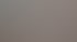 Mechaniker in blauer Uniform tippt auf Laptop auf dem geöffneten Motor eines Autos in einer Werkstatt.