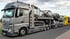 Grauer Mercedes-LKW mit Anhänger transportiert mehrere Autos.