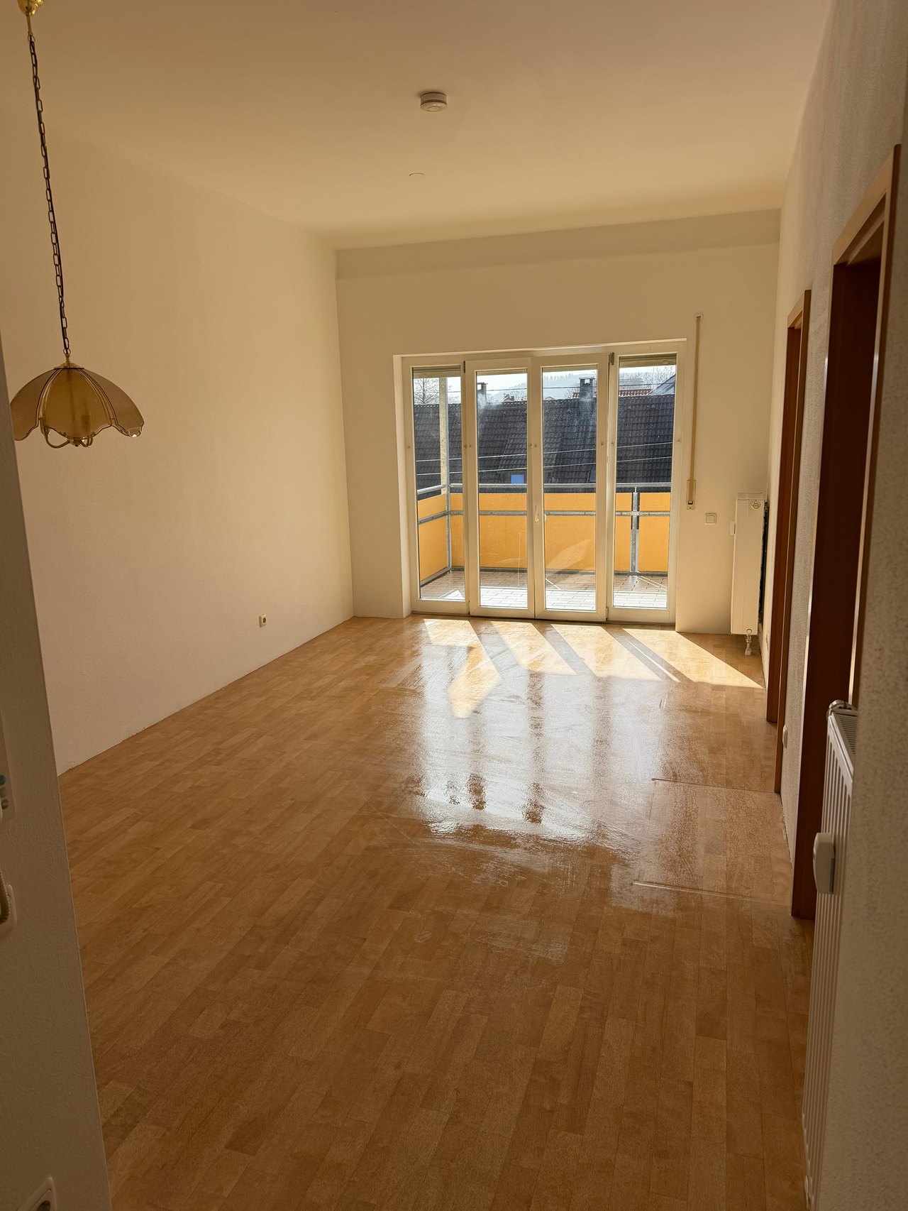 Leeres Wohnzimmer mit Balkon nach einer Haushaltsauflösung