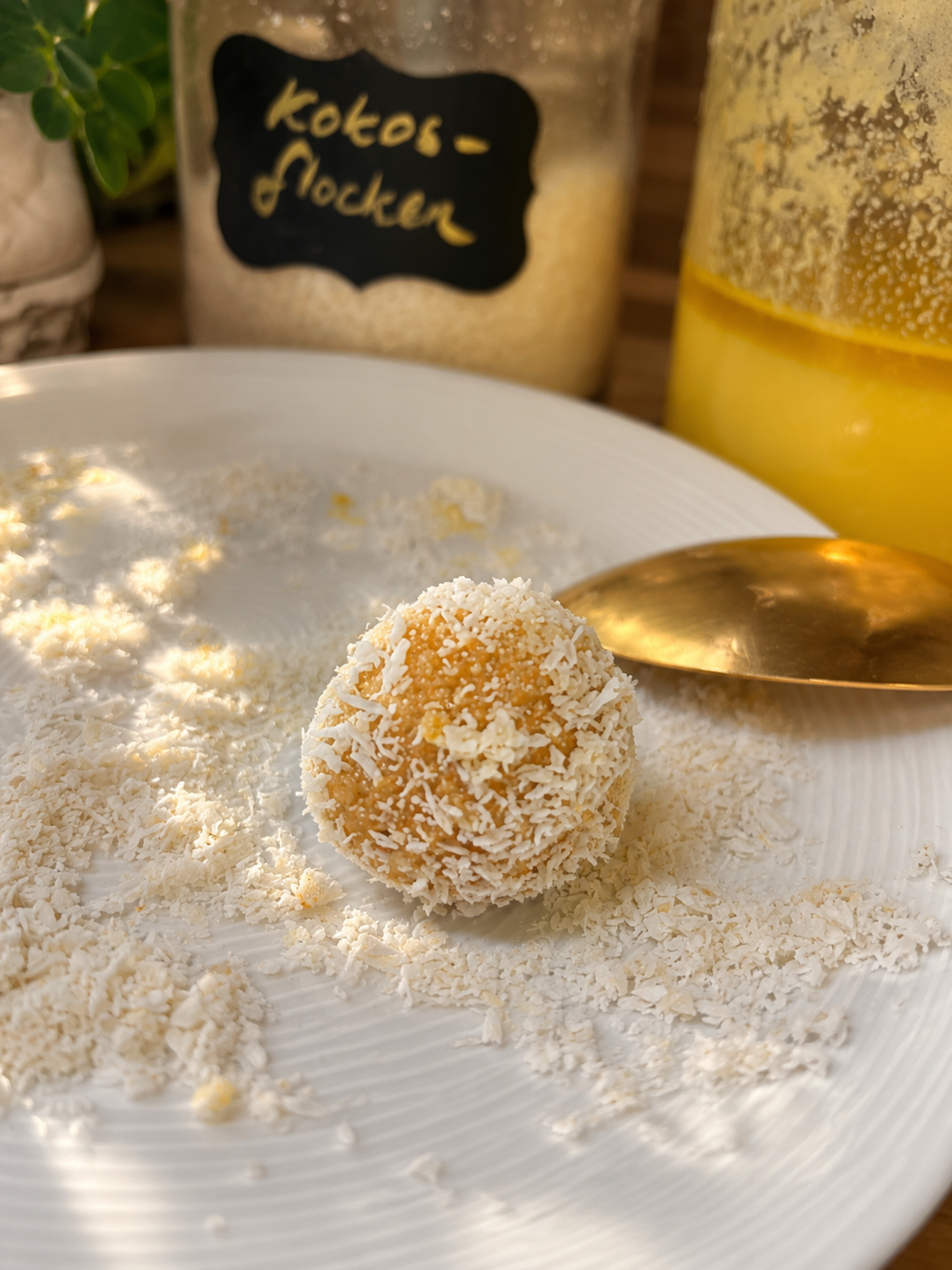 Fertige Laddus, teils in Kokosflocken und essbaren Blüten gewälzt.