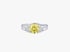 Silberner Ring mit einem großen runden gelben Diamanten und seitlichen kleinen weißen Schmucksteinen auf weißem Hintergrund.