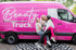 Drei lachende Frauen posieren vor einem pinken "Beauty Truck" Mercedes-Benz Sprinter mit weißer Schrift.