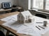 Architektenschreibtisch mit Grundrissen, Hausmodell und Maßstab