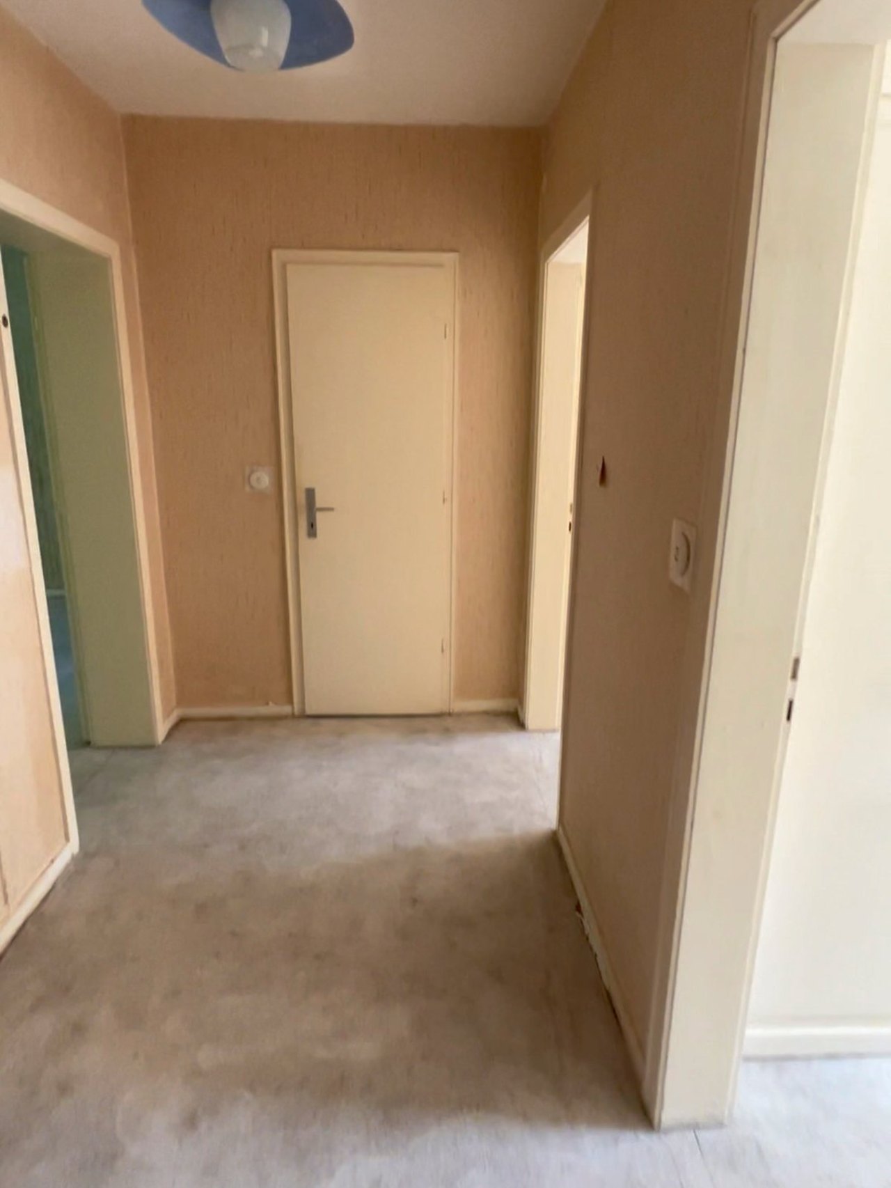 Flur einer Hamburger Wohnung vor der Sanierung: alter Boden, dunkle Türzargen