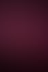 Lächelnde Frau mit Brille, weißem Oberteil und langem rosa Rock steht vor einem pinkfarbenen Hintergrund im Scheinwerferlicht.