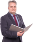 Ein Mann im dunklen Anzug mit roter Krawatte hält ein aufgeschlagenes Ringbuch vor weißem Hintergrund.