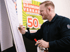 Daniel Solzer, Gründer der update Unternehmerberatung für Einzelhändler und Vollkontakt-Unternehmercoach am Flipchart. Im Hintergrund ein Räumungsverkaufsplakat.