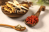 Drei Holzschalen mit traditionellen chinesischen Kräutern: Ginseng, Goji-Beeren und Kapseln.