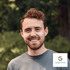 Lachender Mann mit Bart und einem Google Partner-Logo in der unteren rechten Ecke.