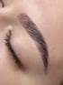 Nahaufnahme einer Augenbraue mit Microblading und eines geschlossenen Auges mit Wimpern.