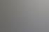 Mann mit kurzen grauen Haaren und einem Lächeln trägt einen dunkelblauen V-Pullover über einem weißen Hemd.