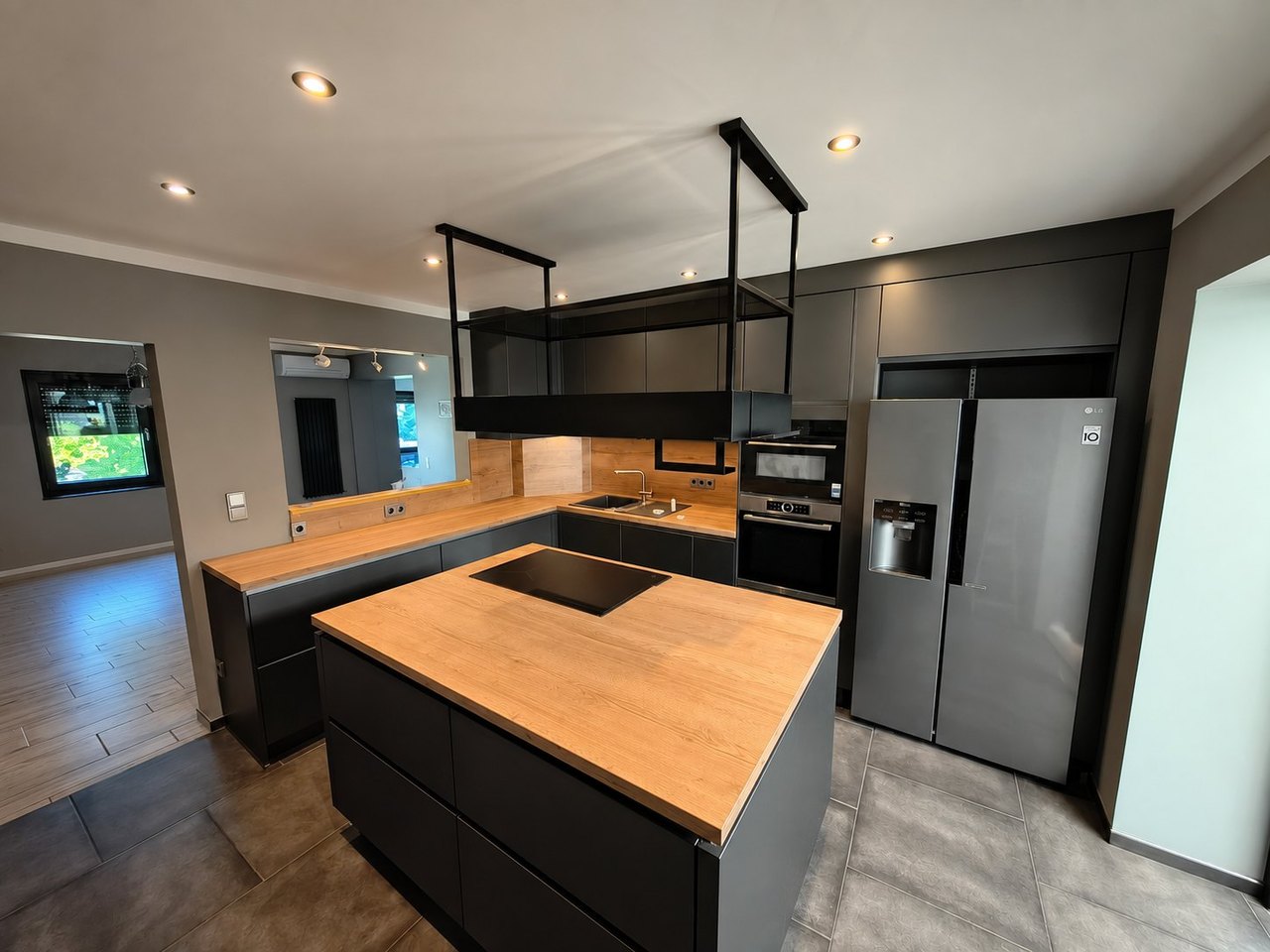 Schwarze Küche mit Kochinsel und Holz, geplant von Baaler Küchenstudio Heinsberg