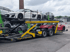 Ein gAutotransporter der Hess Fahrzeuglogistik mit mehreren blauen Neuwagen beladen