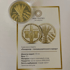 Золота сувенірна медаль «Голодомор – геноцид українського народу» з колосками та руками, на сертифікаті.