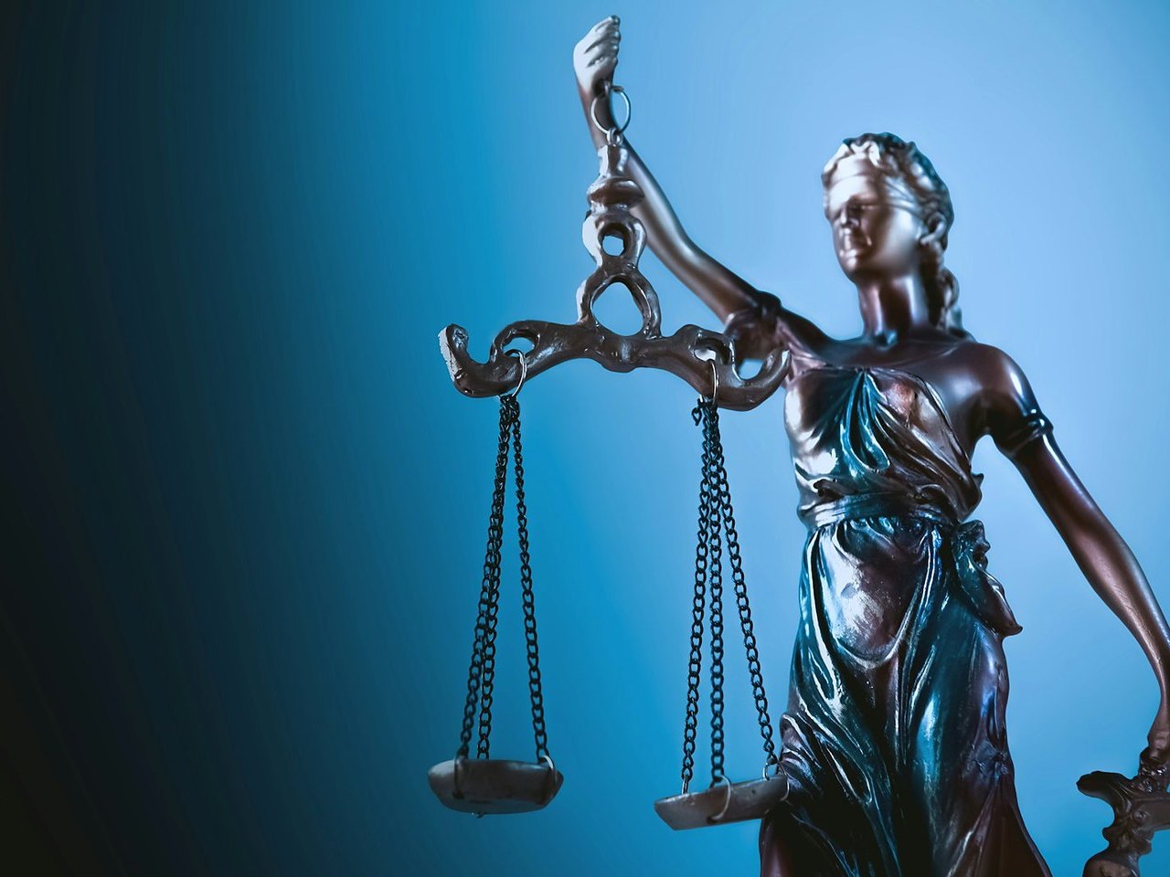 Justitia mit Waage in blauem Licht