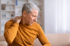 A man holds his neck, experiencing pain or discomfort.