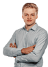 Ein junger Mann mit blonden Haaren und einem weißen Hemd lächelt in die Kamera.