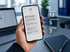 Hand hält Smartphone mit Krisenstab-Nachricht; daneben Statuszahlen: Gesamt 12, ausstehend 5, bestätigt 7 - Software für Alarmierung - Notfall- und Krisenmanager (NKM®).
