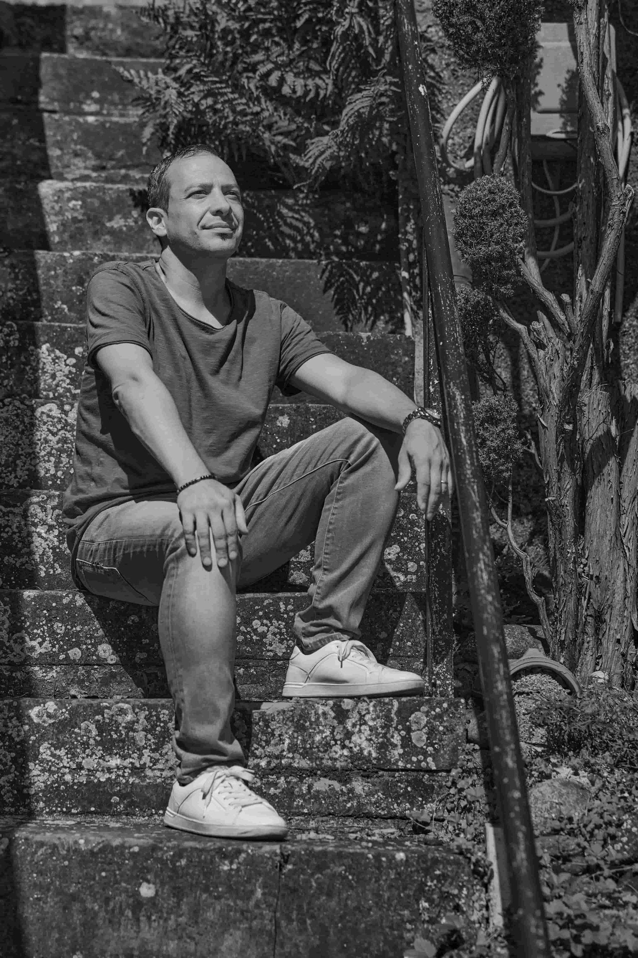 Mario Lovecchio sitzt auf einer Steintreppe im Grünen