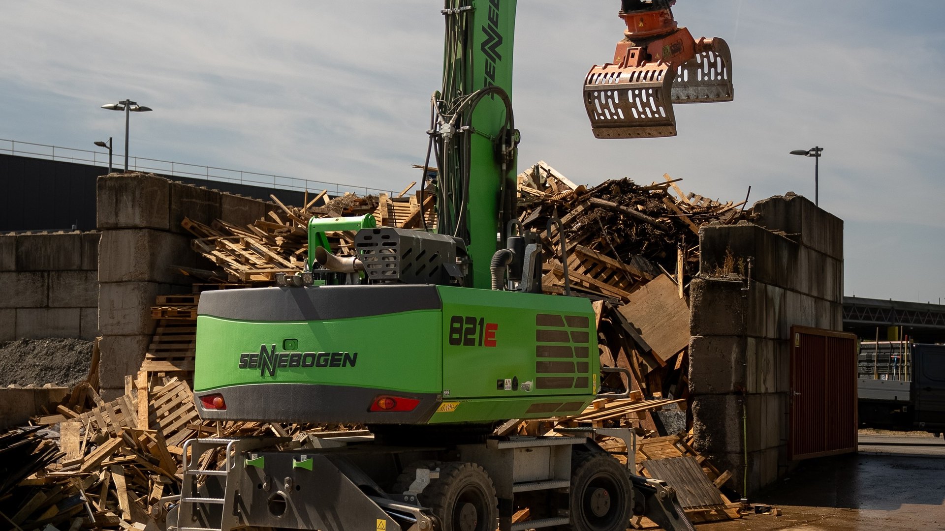 Umschlagbagger sortiert Material in der Recyclinganlage