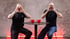 Frank Buschmann und Florian Schmidt-Sommerfeld machen am Stehtisch im Münchner Studio die Ansage-Geste mit den Händen am Mund