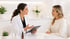 Female doctor shows medical aesthetic results on a tablet to a patient.