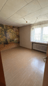 Helles Schlafzimmer der Einliegerwohnung mit großem Fenster, Heizkörper und dekorativer Wald-Fototapete.