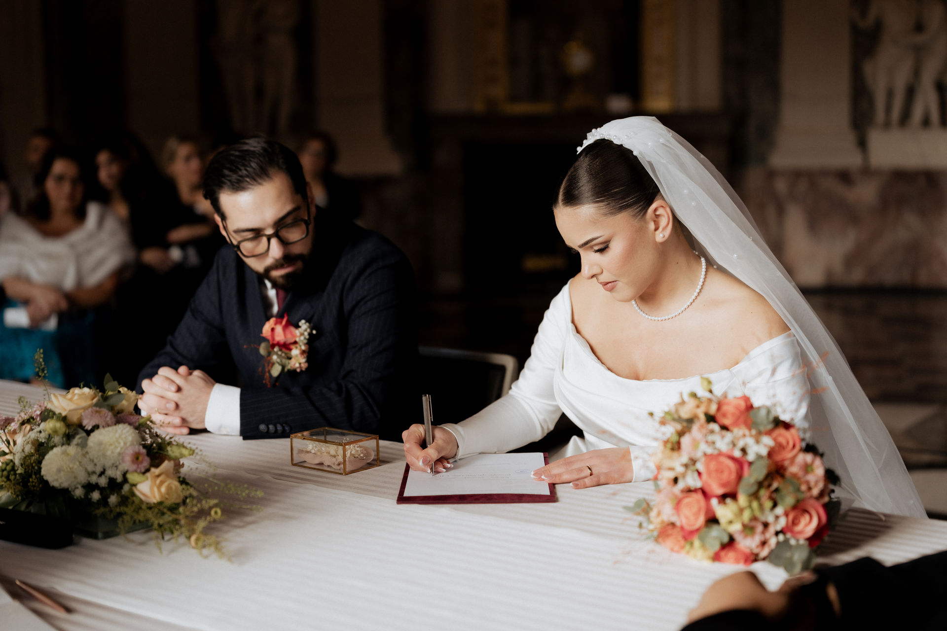 Braut unterschreibt die Eheurkunde bei der standesamtlichen Trauung auf Schloss Benrath in Düsseldorf.