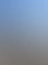 Frau in Sonnenbrille und blauem Cardigan steht an einem Geländer neben einem Fluss unter blauem Himmel.