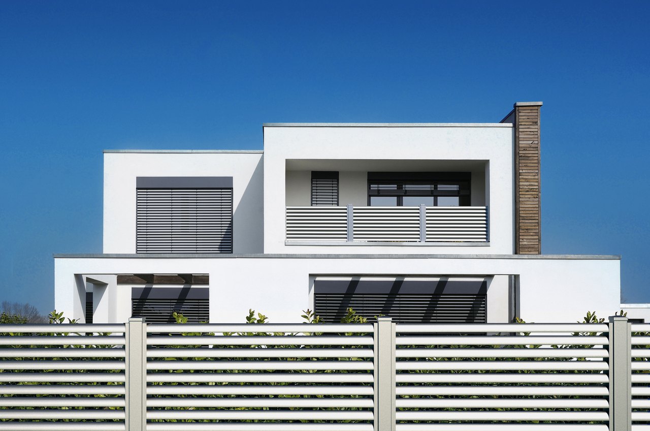 Weisses Haus mit Flachdach und weissem GUARDI Aluminiumbalkon