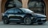 Schwarzer Porsche Macan SUV mit dunklen Felgen vor einem Gebäude mit Torbögen.