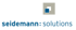 Logo von seidemann: solutions mit einem quadratischen Symbol über dem blauen Schriftzug auf schwarzem Hintergrund.