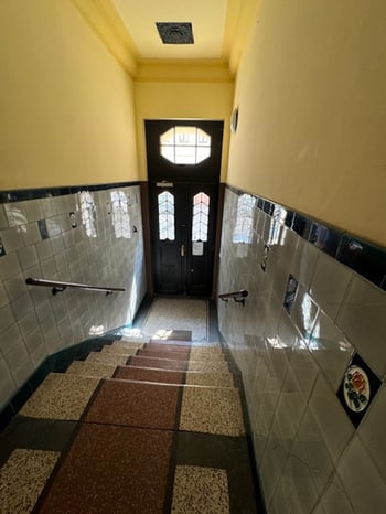 Hauseingang mit gefliestem Flur und Treppe zum Treppenhaus