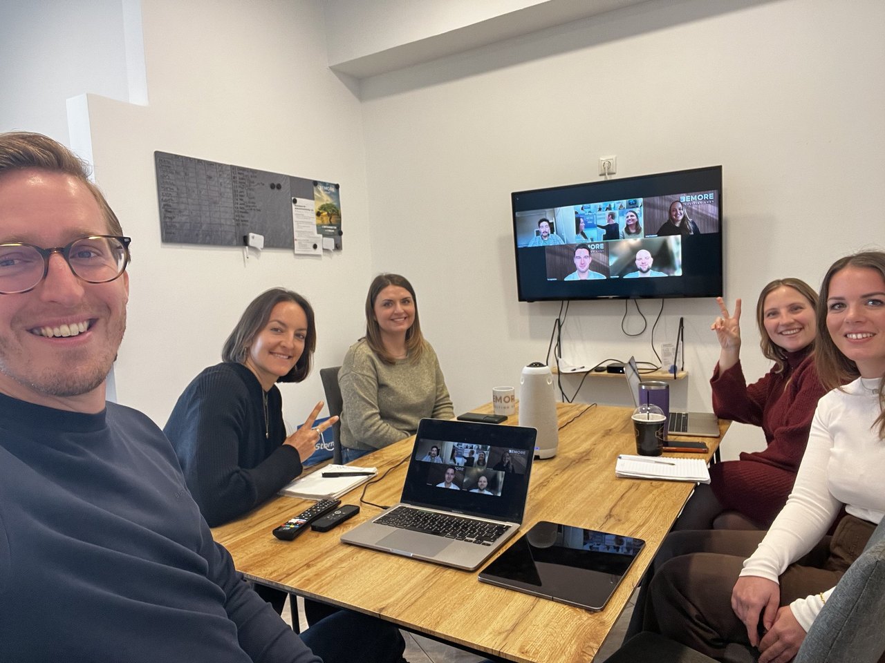 Das Team im Meetingraum bei einer Videokonferenz