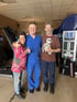 A doctor and clients smiling in an office.


