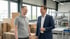 Zwei lachende Männer in einer Fabrikhalle mit Kartons und Maschinen im Hintergrund.