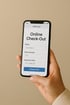 Hand hält Smartphone mit Online-Check-Out-Formular: Name, Zimmernummer 123, Abreisedatum und „Check Out“-Button.