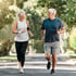 An older couple happily jogging outdoors with the help of chiropractic adustments