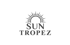 Graues Logo "SUN TROPEZ" mit einer Sonne darüber auf dunklem Hintergrund.